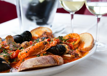 Horizontal sea food tomatoes mediterranean soup with bread and glass of white wine